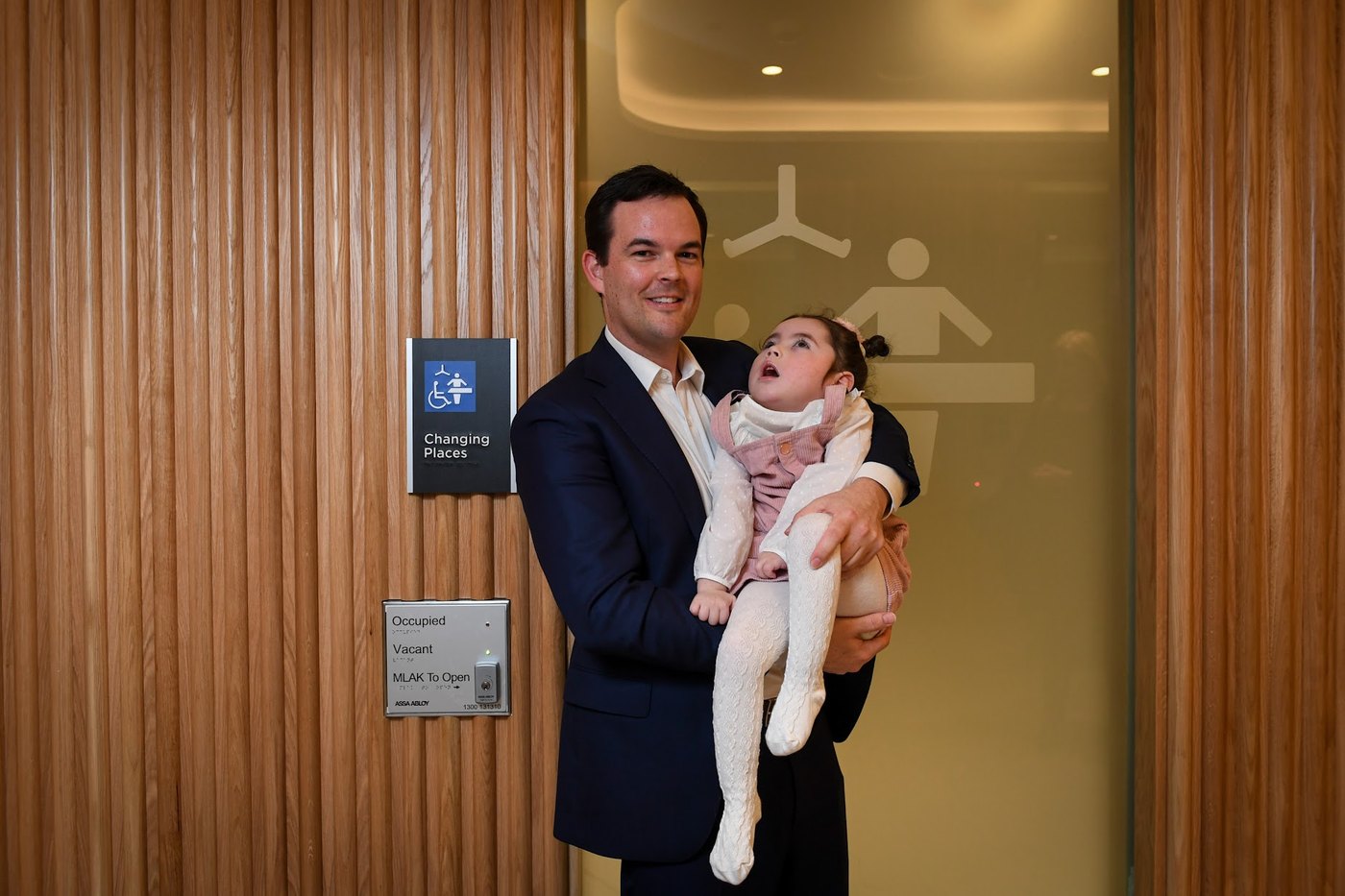 Glen Atwell holding his daughter Ivy outside a Changing Places facility