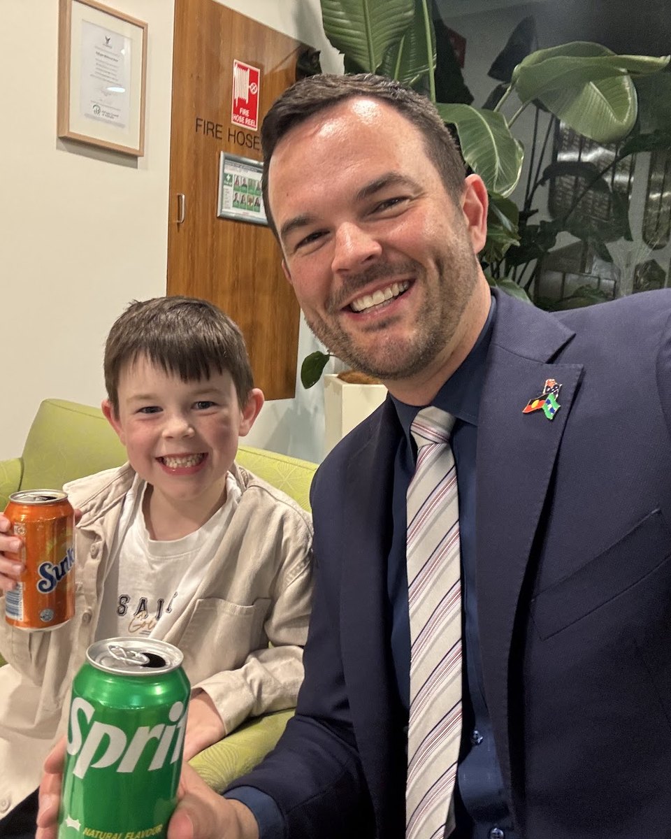 Glen Atwell and his son Austin with cans of soft drink in the council foyer